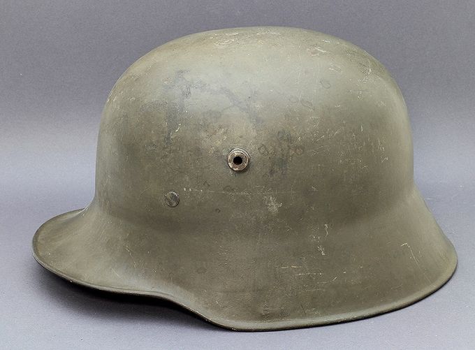 M18 W66 (Hermann Weissenburger & Co., Stuttgart-Cannstatt) med grønn WWI fabrikkmaling. Denne hjelmen ble tatt fra et depot i Grorud (Oslo) som flere andre og var sikkert tenkt til å bli brukt som den var eller å bli gjenbrukt med ny maling, ny hakereim og ny lærinnmat. 
